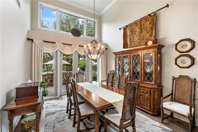 a view of a dining room with furniture a chandelier and wooden floor