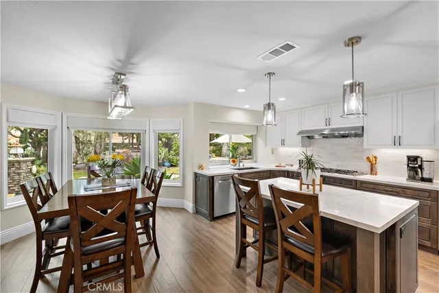 a view of a dining room and livingroom with furniture wooden floor a chandelier