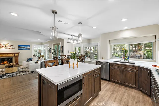 a large kitchen with kitchen island a stove a sink a center island and wooden floor