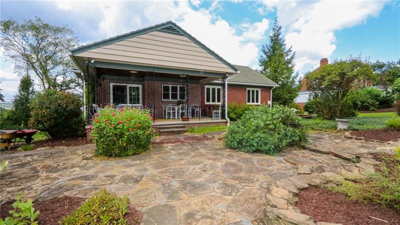 29 Swallow Hill Road Carnegie, PA 15106 - Photo 2 of 25 Exterior of home showing stone patio and covered back porch.