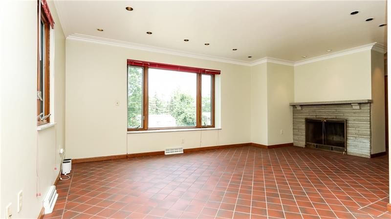 29 Swallow Hill Road Carnegie, PA 15106 - Photo 7 of 25 Living room showing corner fireplace, big picture windows and terra cotta flooring.