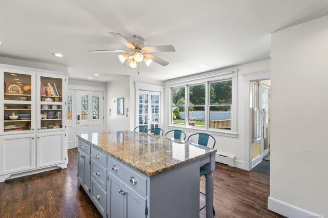 a dining hall with stainless steel appliances granite countertop a kitchen island a stove a sink a dining table and chairs