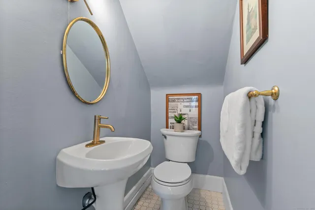 a bathroom with a toilet sink and mirror