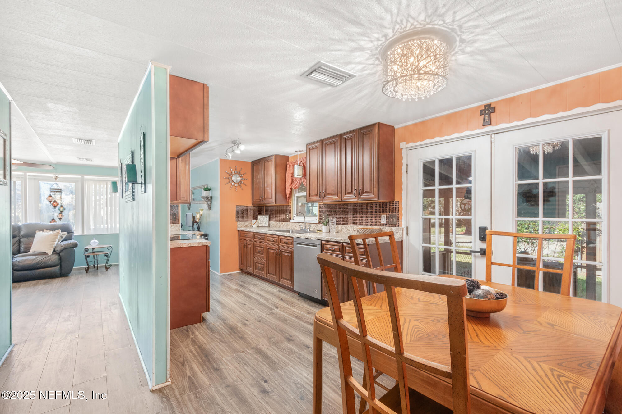 106 Deltona Boulevard St. Augustine, FL 32086 - Photo 15 of 36 a open kitchen with stainless steel appliances granite countertop a refrigerator a stove top oven a sink dishwasher and couches with wooden floor