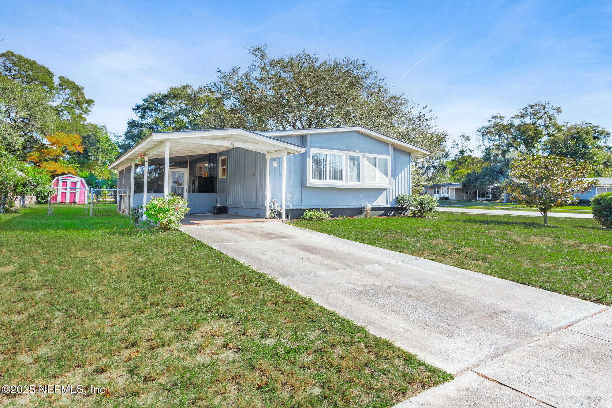 106 Deltona Boulevard St. Augustine, FL 32086 - Photo 21 of 36 a front view of a house with a garden and trees