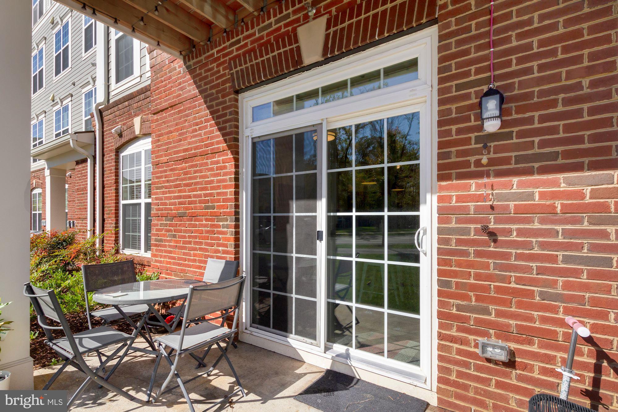 3825 Doc Berlin Drive, Unit 17 Silver Spring, MD 20906 - Photo 28 of 34 a view of a brick building with chairs and table in a patio