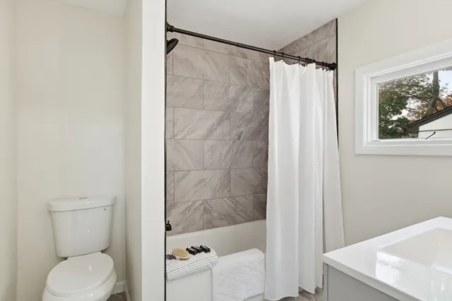 a bathroom with a shower curtain and a toilet