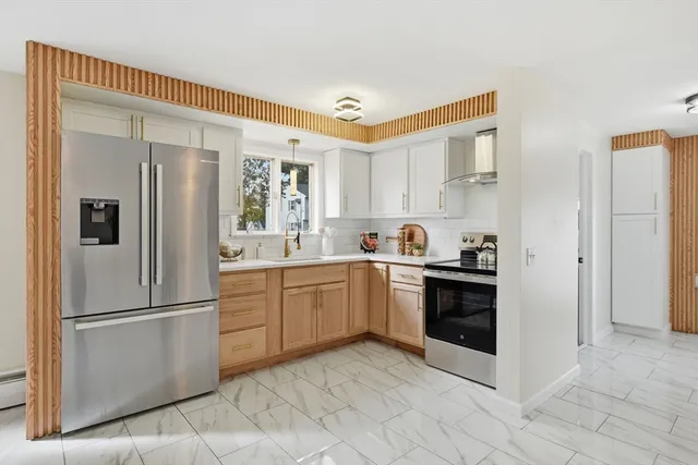 a kitchen with stainless steel appliances granite countertop a refrigerator sink and stove