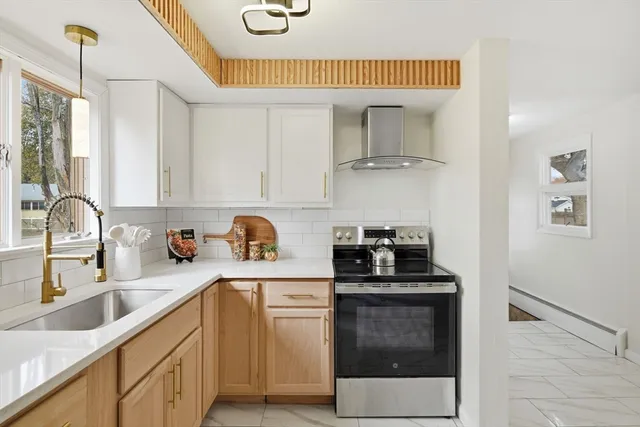 a kitchen with granite countertop a sink cabinets and stainless steel appliances