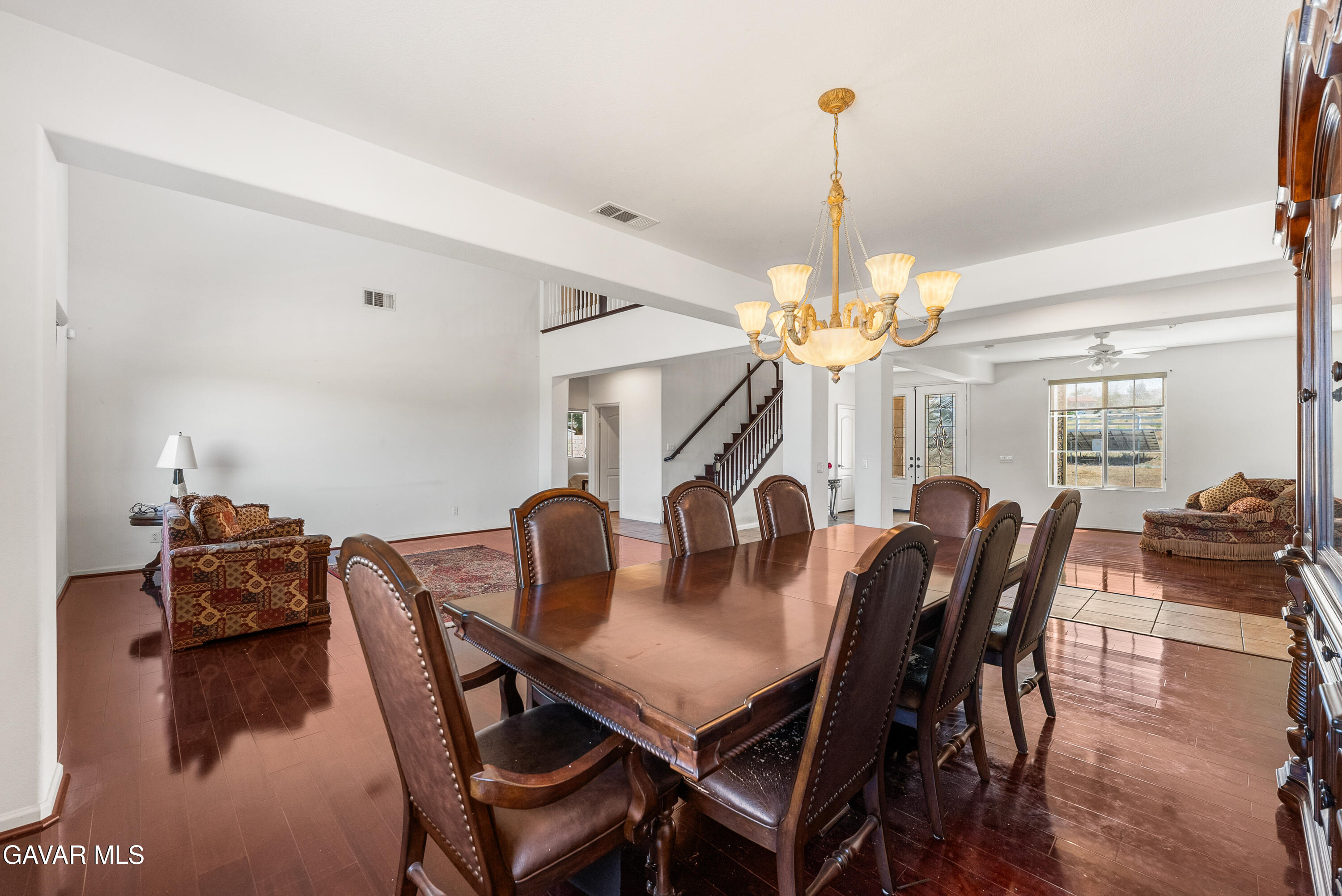 658 Lago Lindo Road Palmdale, CA 93550 - Photo 19 of 91 a view of a dining room with furniture a chandelier and wooden floor