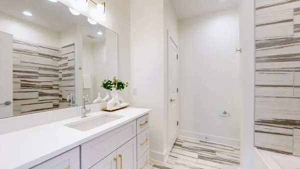 a bathroom with a sink a potted plant and a window