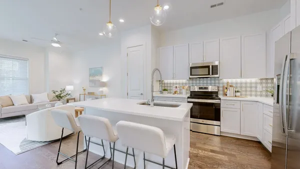 a kitchen with stainless steel appliances a stove a sink a microwave a refrigerator a stove a dining table and chairs