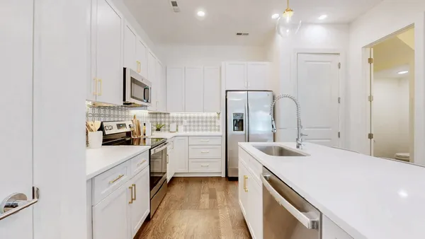 a kitchen with white cabinets and stainless steel appliances