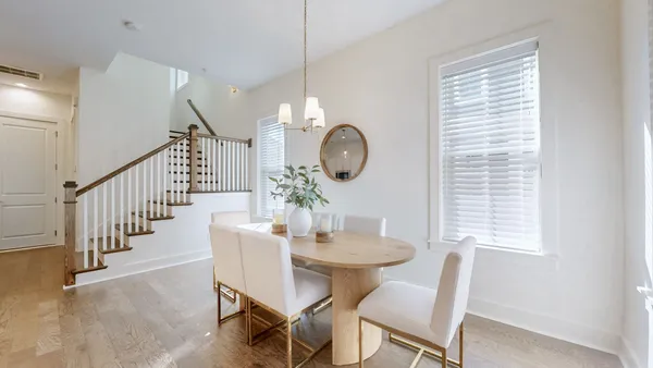 a dining room with furniture a potted plant and a window