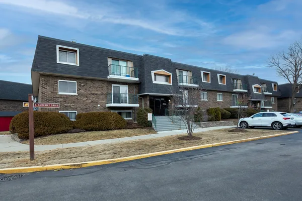a view of a car park in front of a brick house