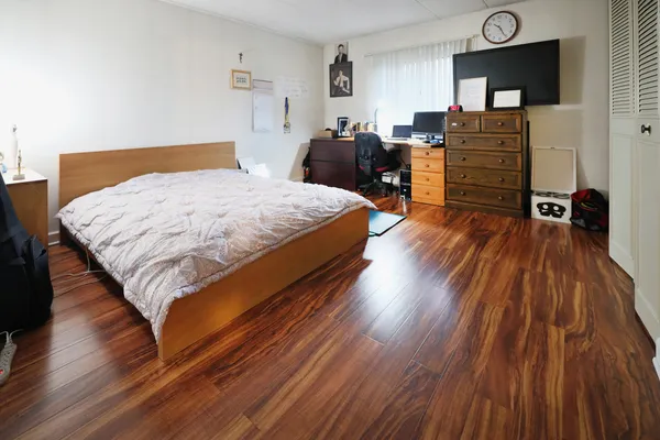 a bedroom with a bed and wooden floor