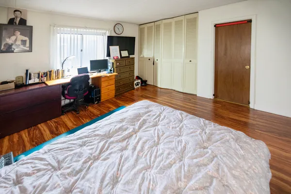 a living room with a bed furniture and a flat screen tv