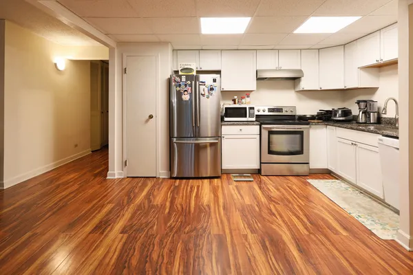 a kitchen with granite countertop wooden floors and stainless steel appliances