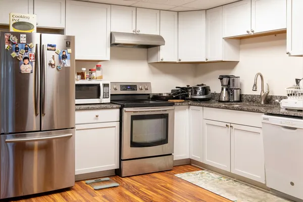 a kitchen with stainless steel appliances granite countertop a refrigerator sink and stove