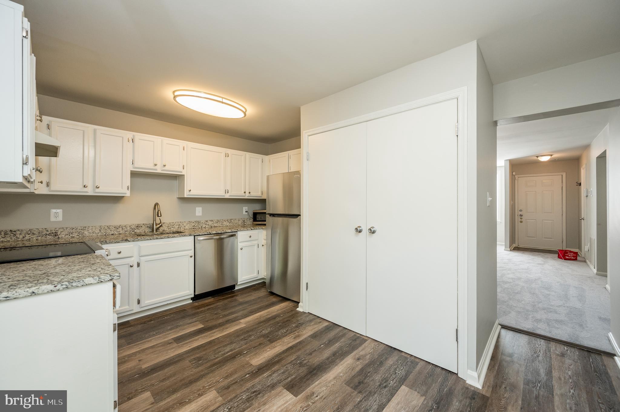 6128 Old Landing Way, Unit 75 Burke, VA 22015 - Photo 16 of 25 a kitchen with granite countertop white cabinets and white appliances