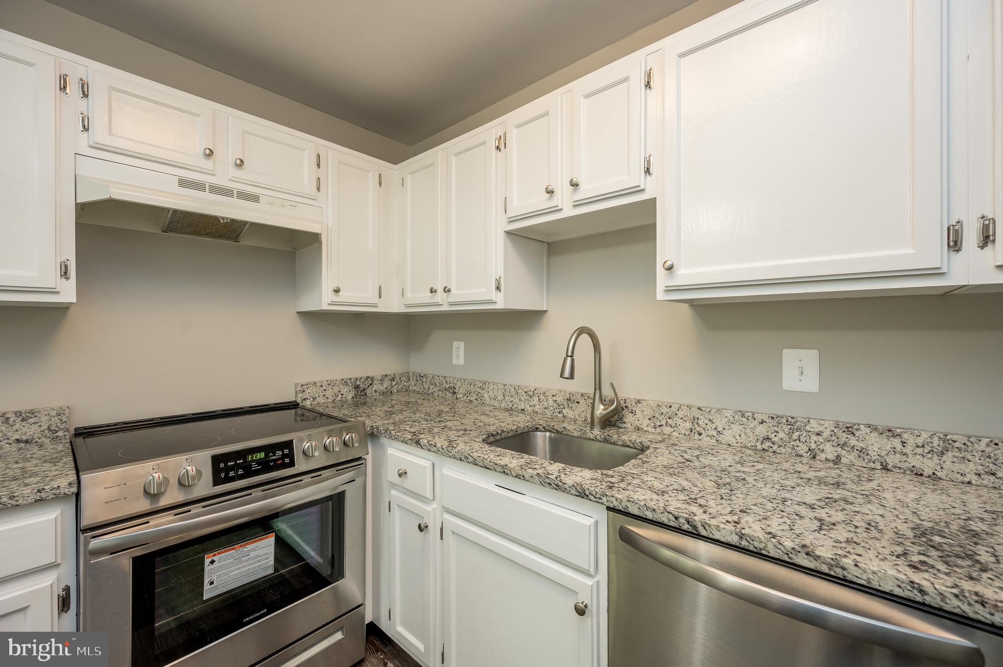 6128 Old Landing Way, Unit 75 Burke, VA 22015 - Photo 17 of 25 a kitchen with granite countertop a stove sink and cabinets