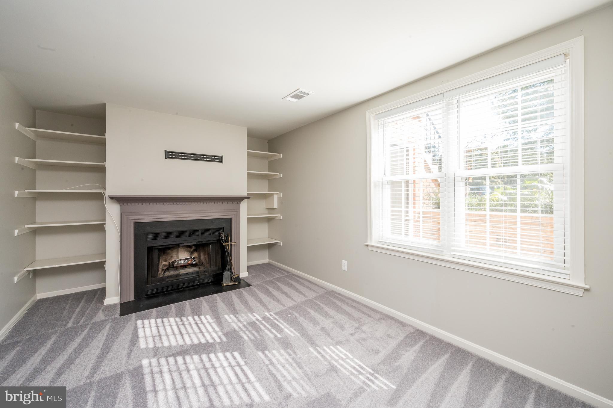 6128 Old Landing Way, Unit 75 Burke, VA 22015 - Photo 2 of 25 a view of an empty room with a window and fireplace