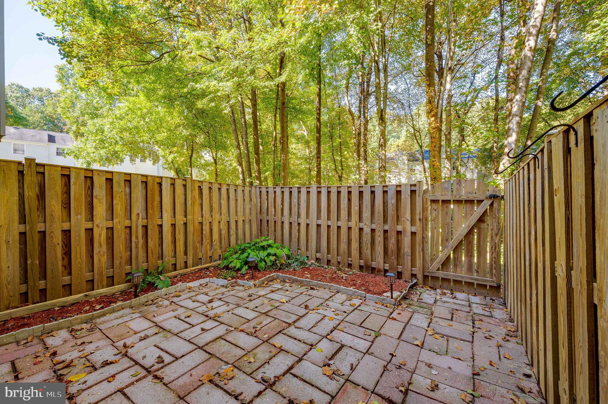 6128 Old Landing Way, Unit 75 Burke, VA 22015 - Photo 5 of 25 a view of a pathway gate with wooden fence