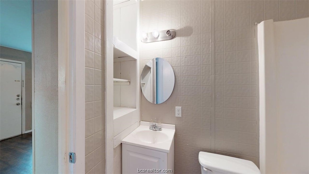 204 Lynn Drive, Unit B Bryan, TX 77801 - Photo 11 of 17 a bathroom with a toilet a sink and mirror