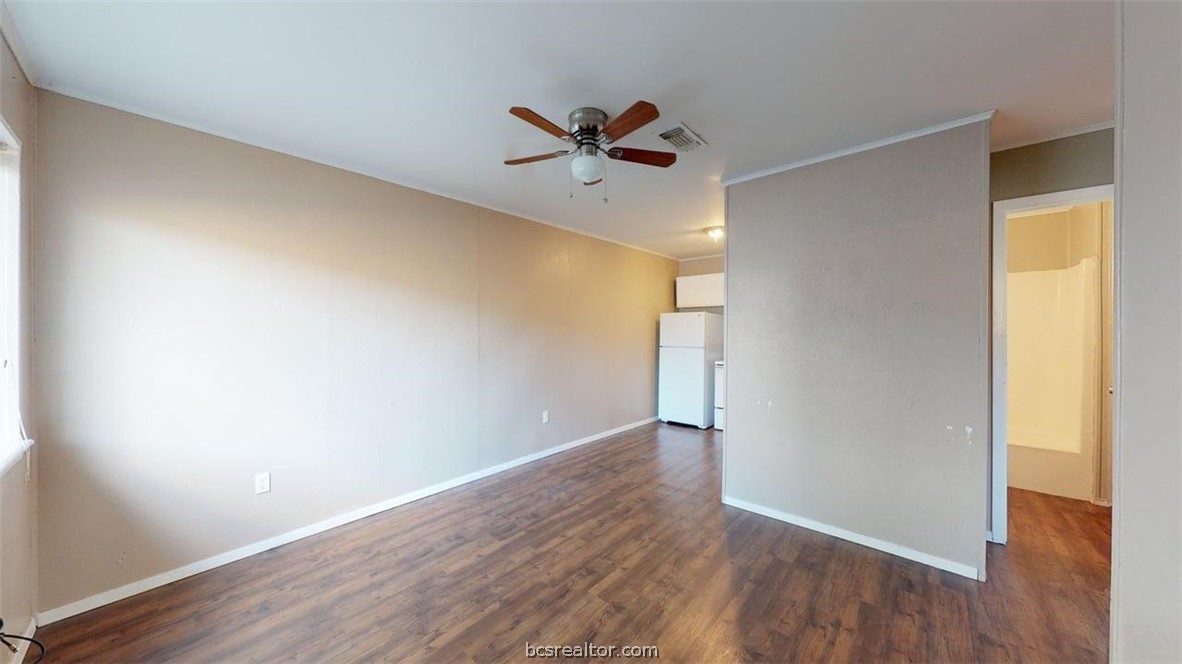 204 Lynn Drive, Unit B Bryan, TX 77801 - Photo 2 of 17 a view of an empty room with wooden floor and a window