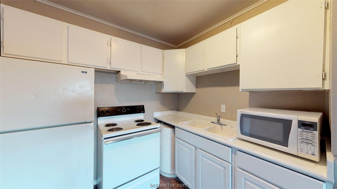 204 Lynn Drive, Unit B Bryan, TX 77801 - Photo 6 of 17 a kitchen with a sink and a stove top oven