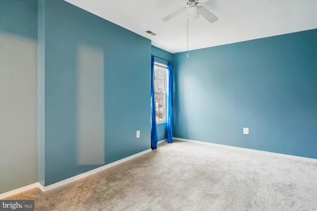 a view of an empty room with a ceiling fan
