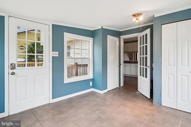 a view of an empty room with a chandelier fan