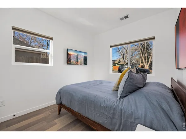 a bedroom with a bed and wooden floor