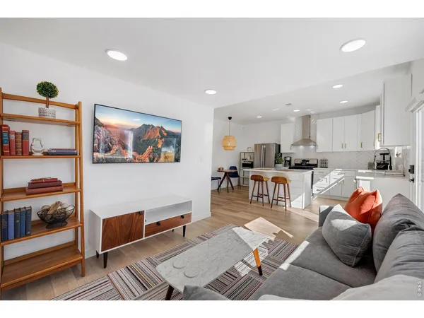 a living room with furniture and a view of kitchen
