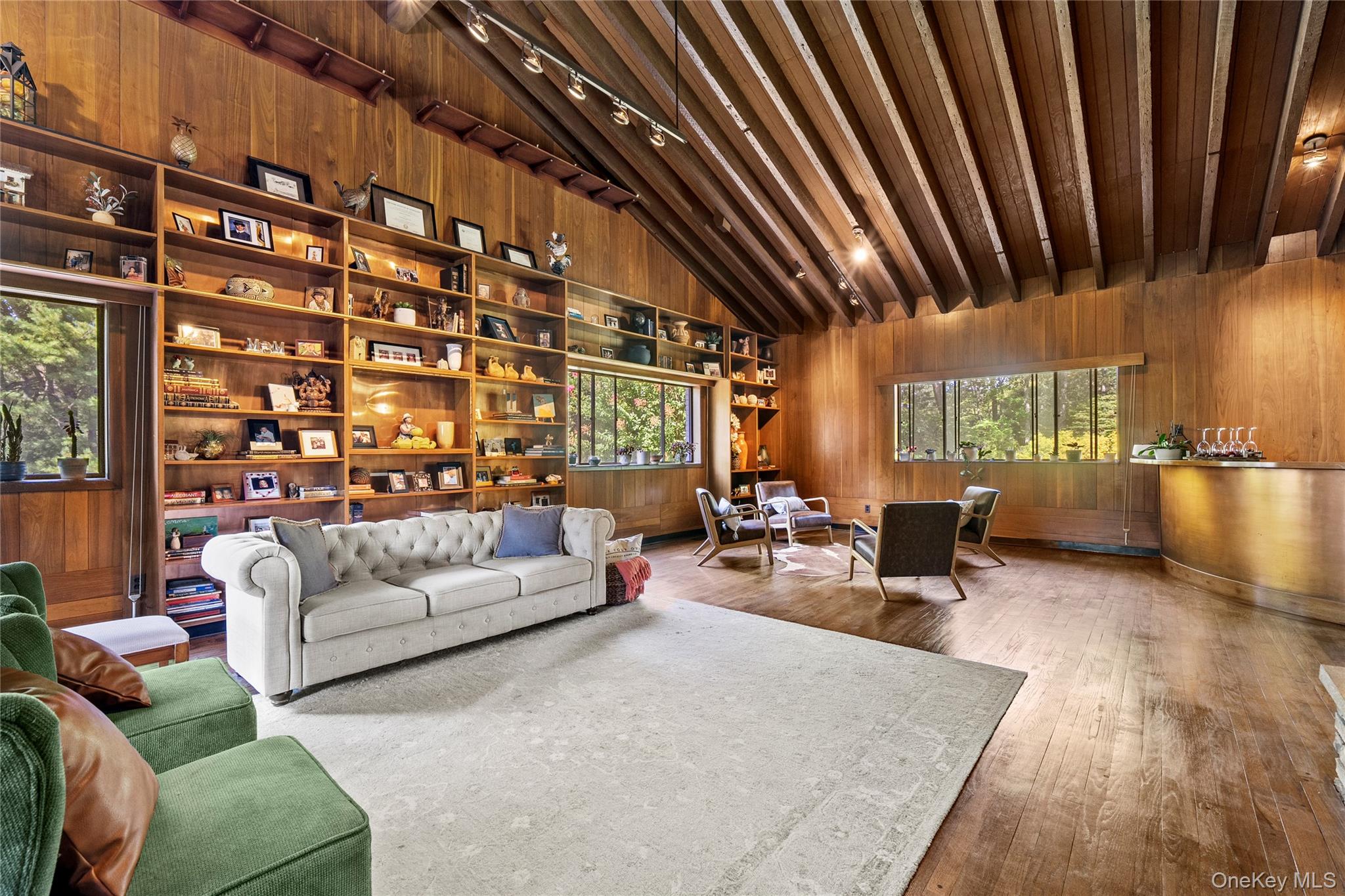 55 Rolling Hill Lane Old Westbury, NY 11568 - Photo 12 of 48 Living area featuring wood walls, plenty of natural light, high vaulted ceiling, wood-type flooring, and track lighting