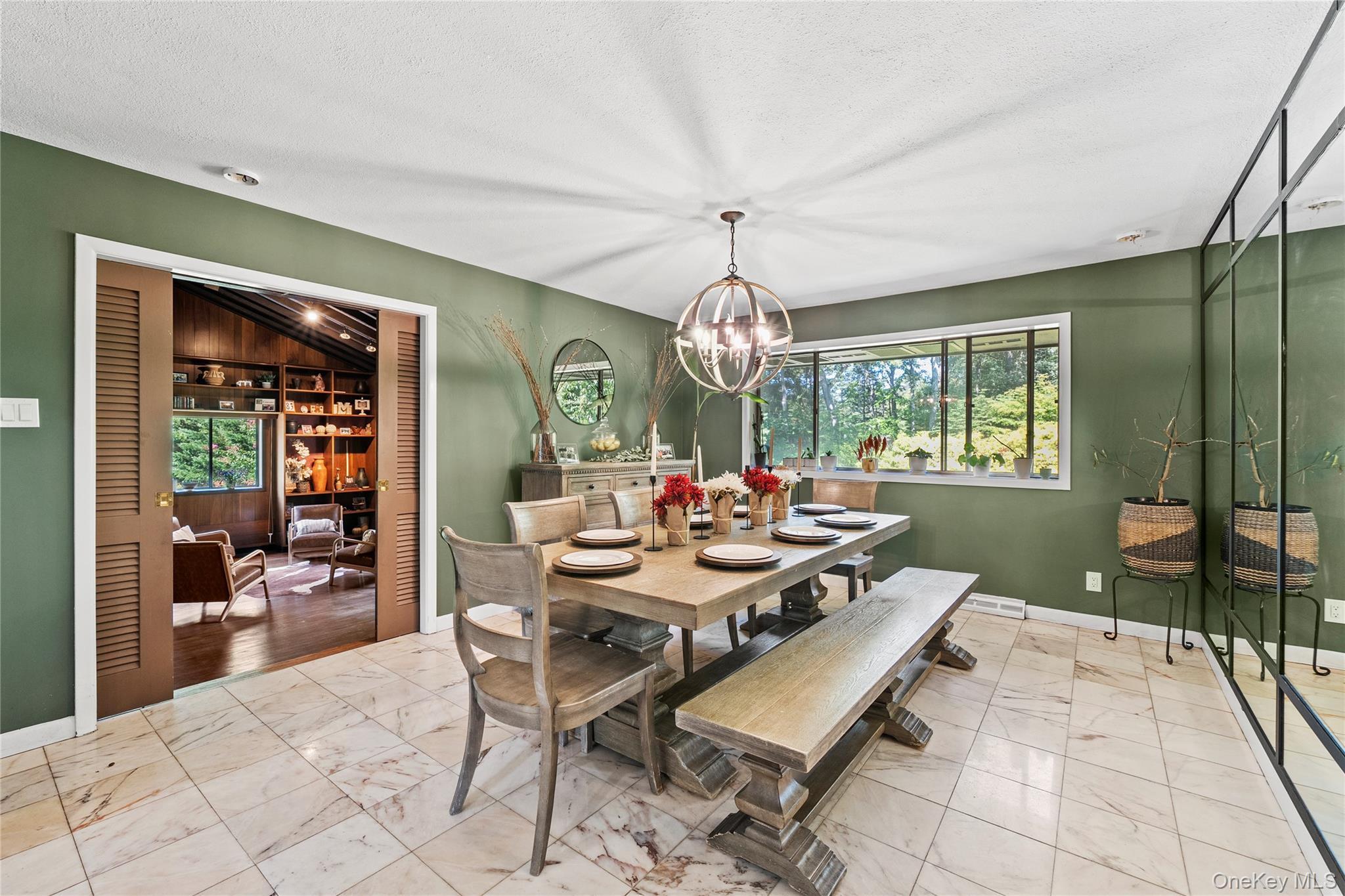 55 Rolling Hill Lane Old Westbury, NY 11568 - Photo 14 of 48 Dining area featuring light marble finish flooring, a textured ceiling, and a chandelier