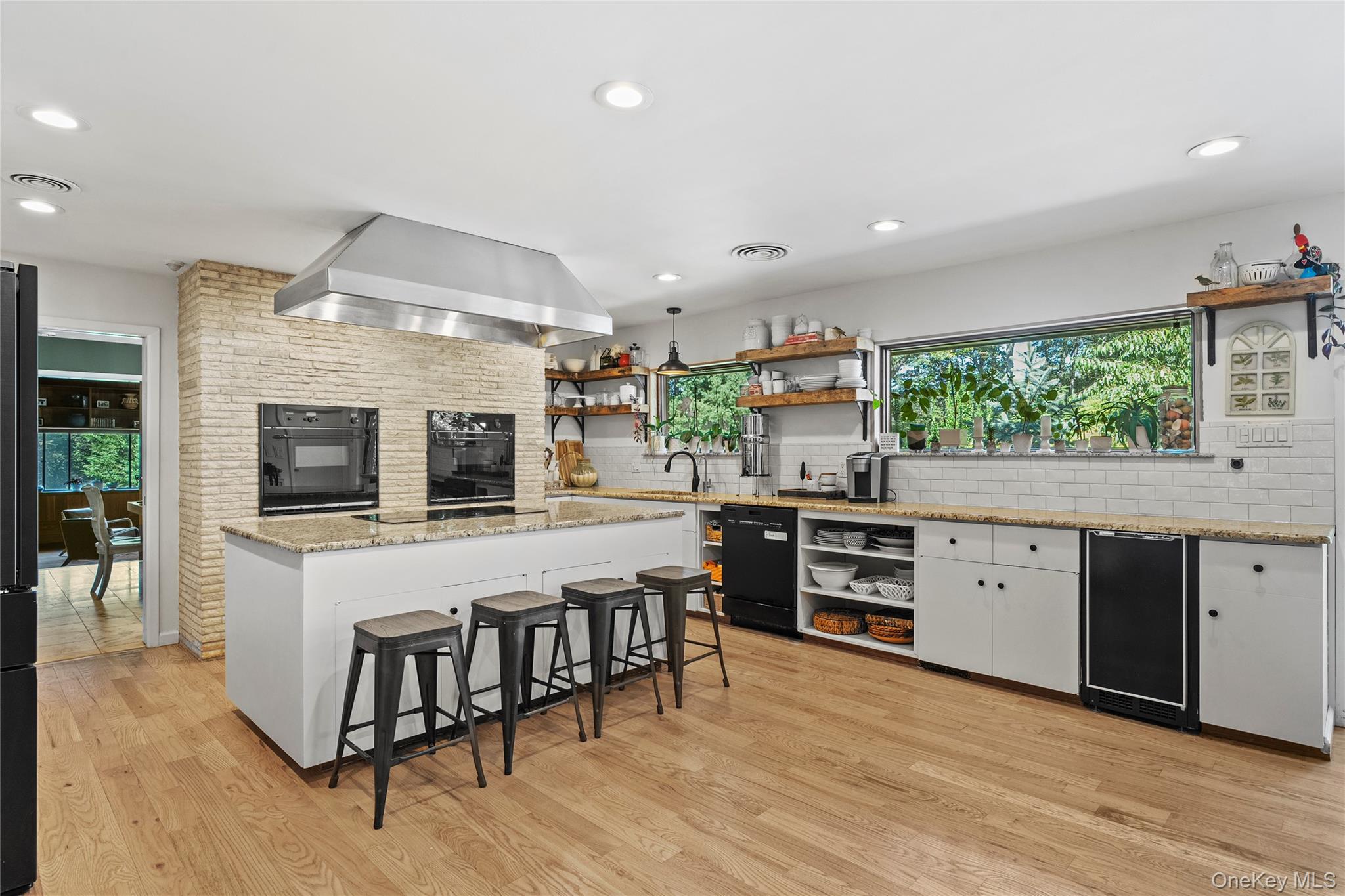 55 Rolling Hill Lane Old Westbury, NY 11568 - Photo 16 of 48 Kitchen featuring open shelves, light stone counters, a breakfast bar, light wood-style floors, and recessed lighting