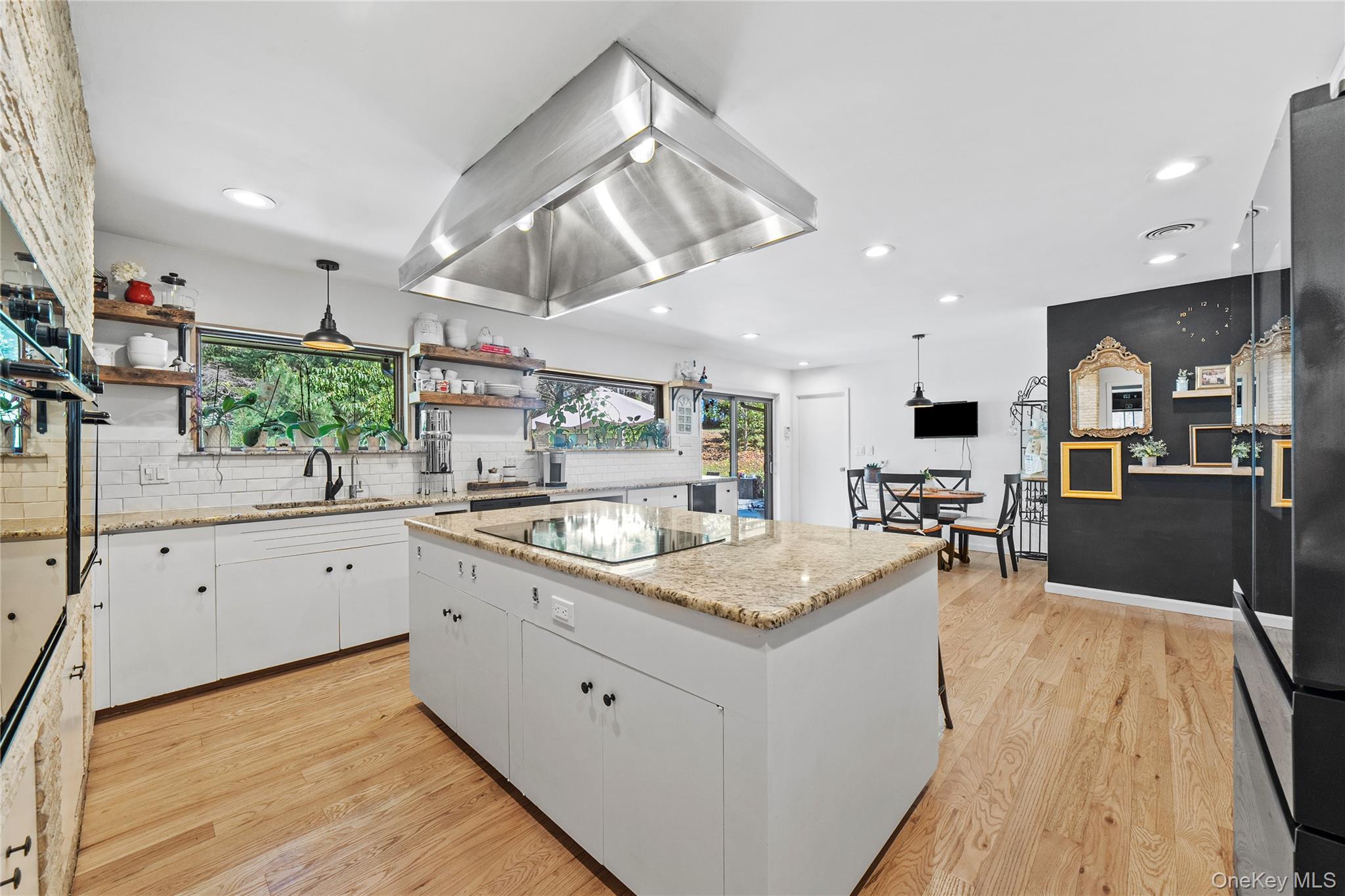 55 Rolling Hill Lane Old Westbury, NY 11568 - Photo 18 of 48 Kitchen with decorative light fixtures, white cabinetry, a kitchen island, light wood-style flooring, and recessed lighting