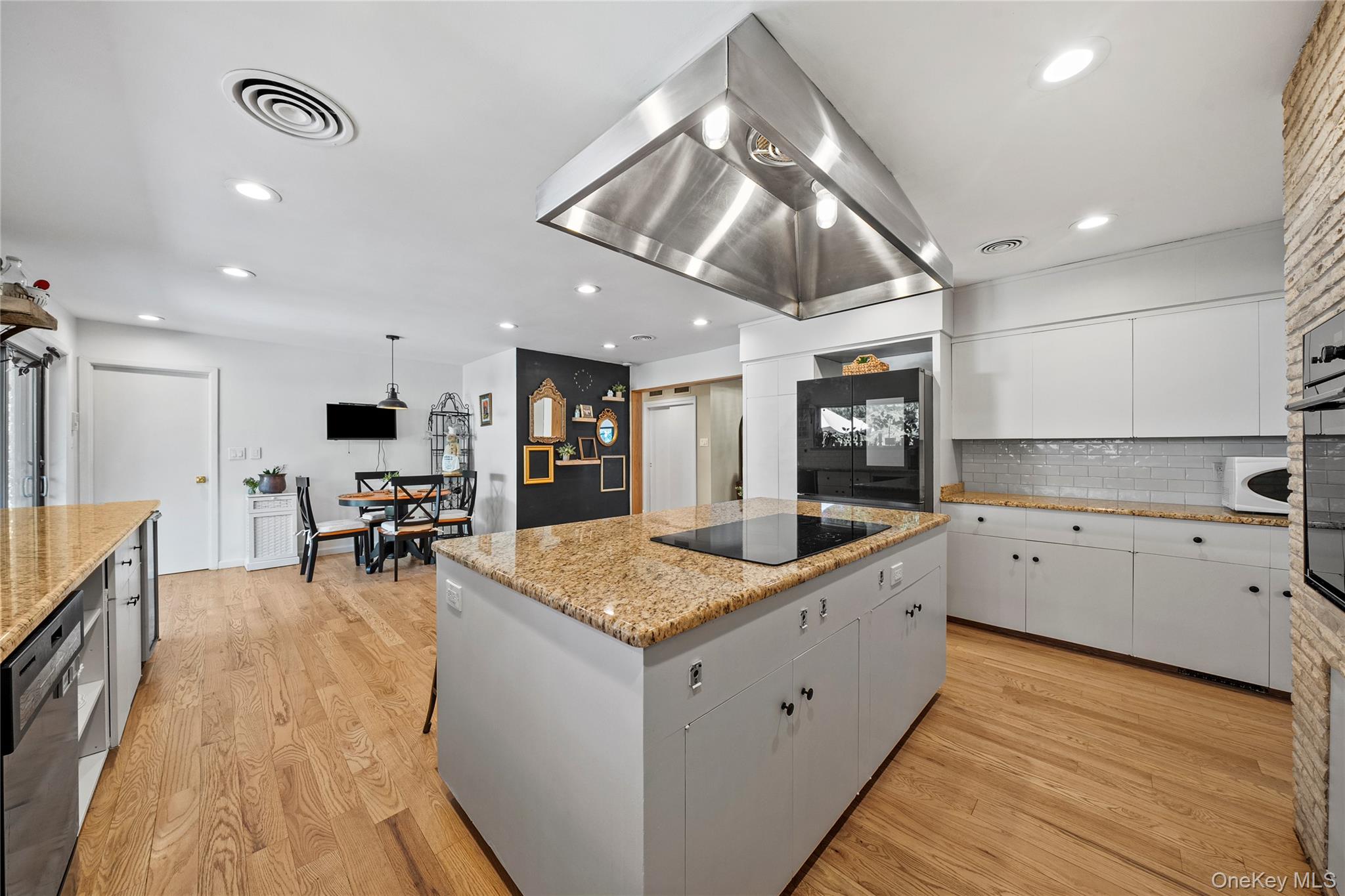 55 Rolling Hill Lane Old Westbury, NY 11568 - Photo 19 of 48 Kitchen with tasteful backsplash, a kitchen island, island range hood, white cabinetry, and light wood-style floors
