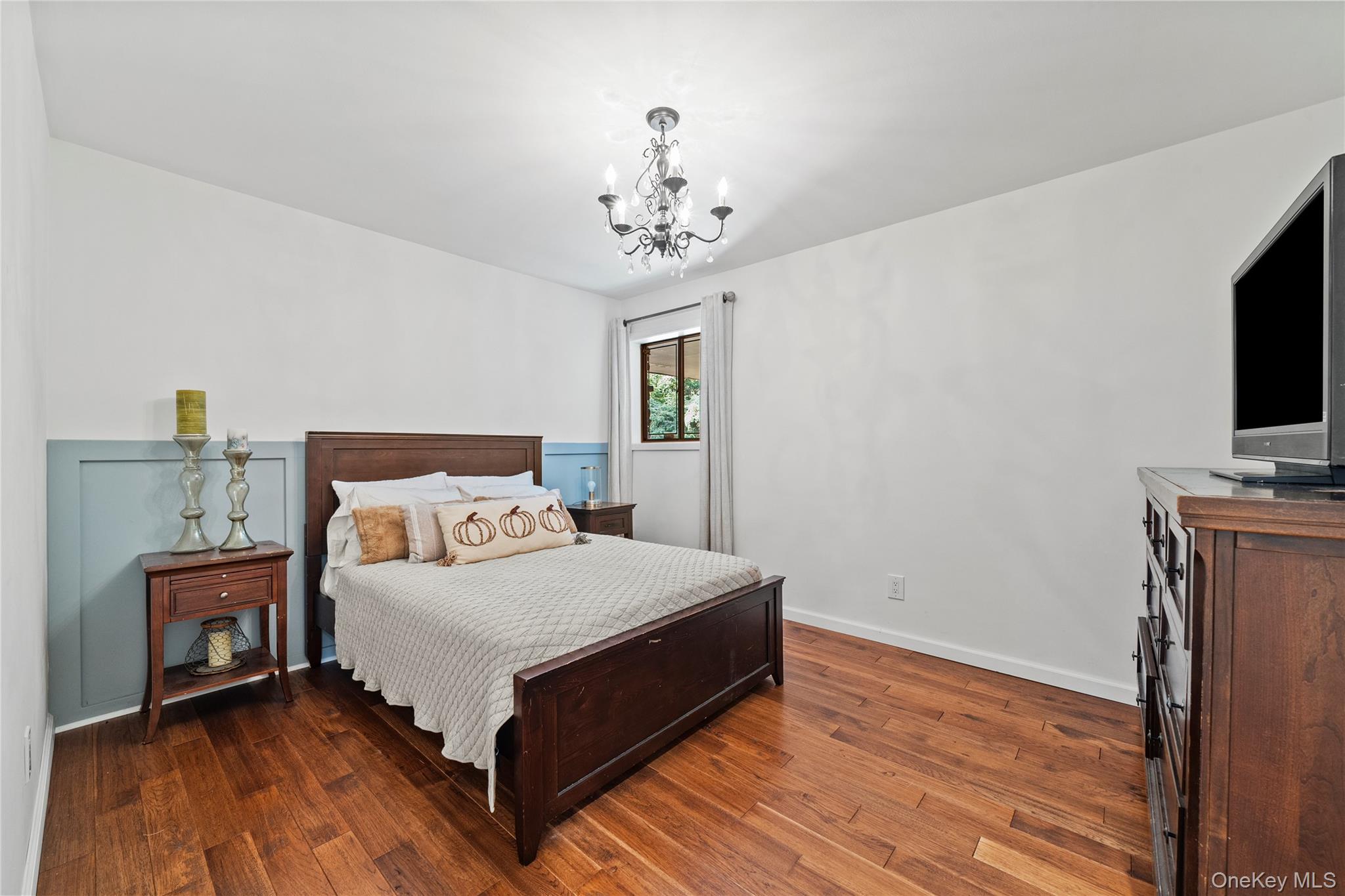 55 Rolling Hill Lane Old Westbury, NY 11568 - Photo 27 of 48 Bedroom with dark wood-type flooring and a chandelier