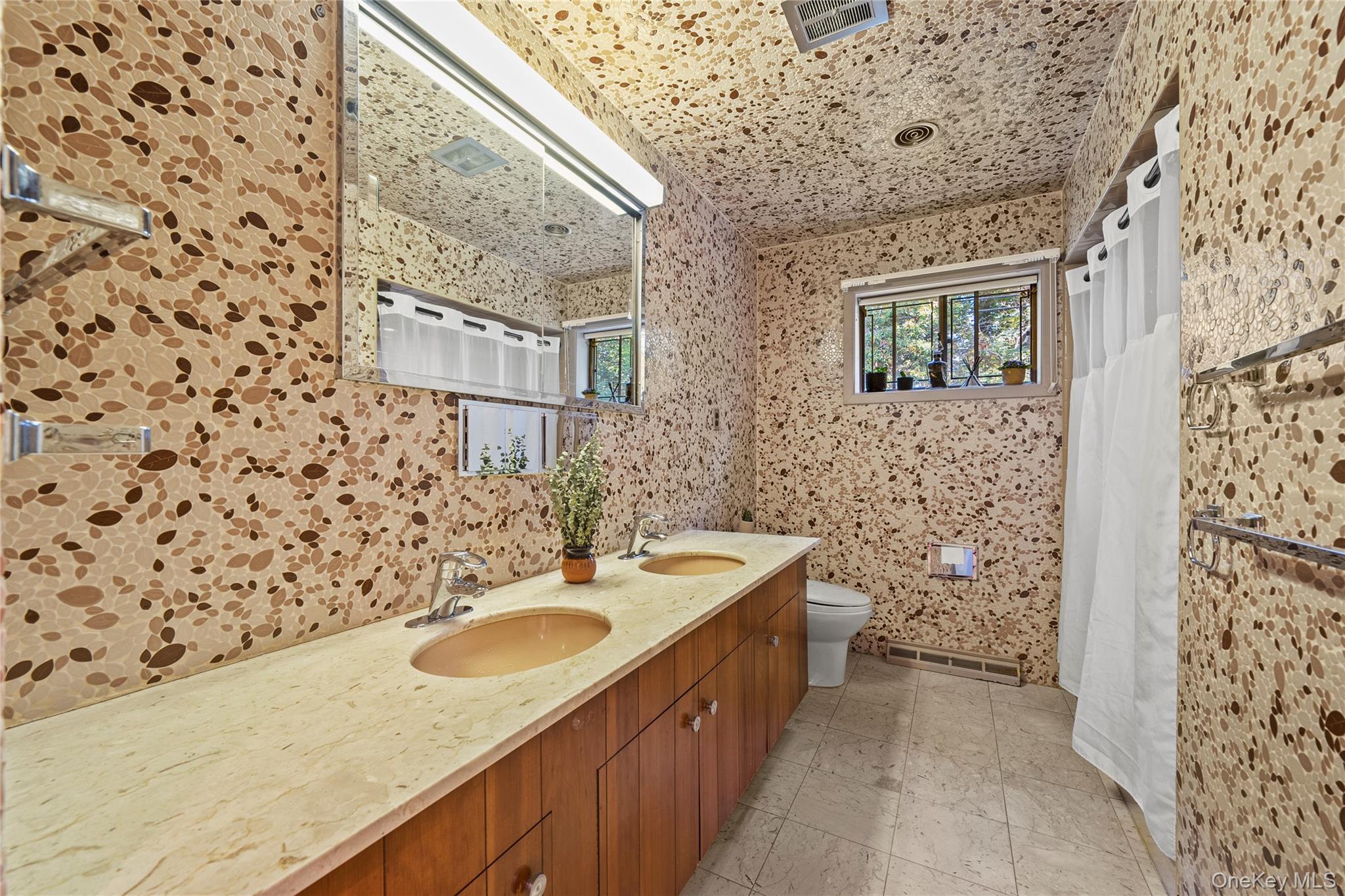 55 Rolling Hill Lane Old Westbury, NY 11568 - Photo 28 of 48 Bathroom with double vanity, a shower with curtain, and tile walls