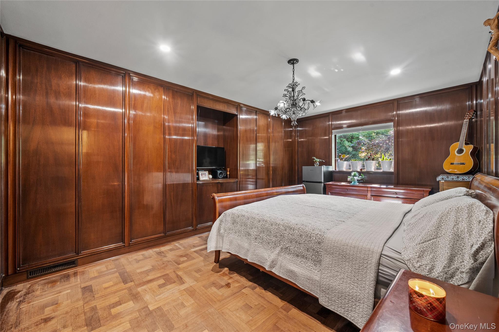 55 Rolling Hill Lane Old Westbury, NY 11568 - Photo 30 of 48 Bedroom featuring wood walls and a chandelier