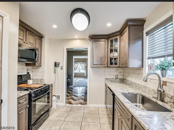 a kitchen with granite countertop a sink and a stove top oven