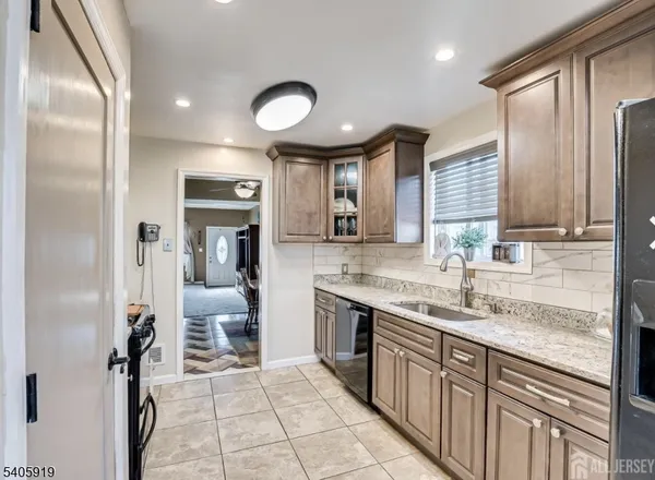 a large kitchen with stainless steel appliances granite countertop a sink and cabinets
