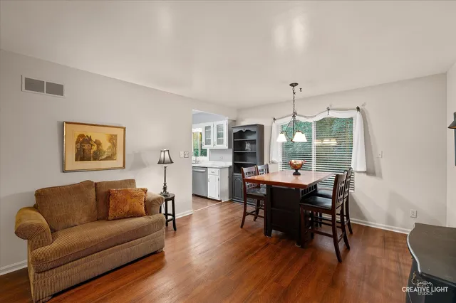 a living room with furniture a dining table and a large window