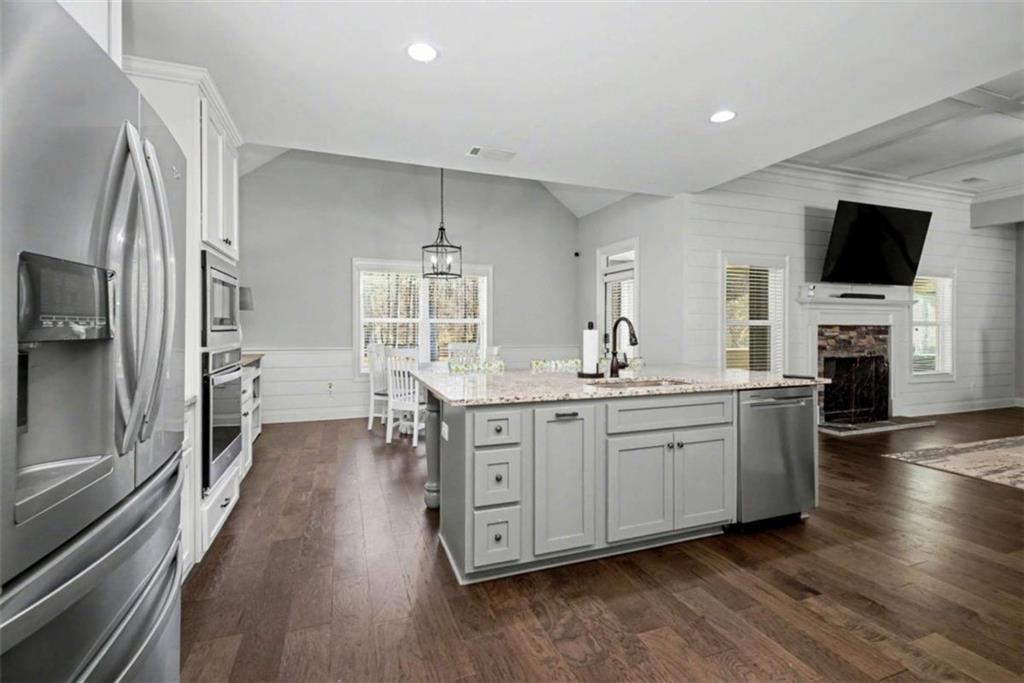 92 Gordon Oaks Way Moreland, GA 30259 - Photo 12 of 54 a large kitchen with stainless steel appliances a large counter top a stove and a wooden floors