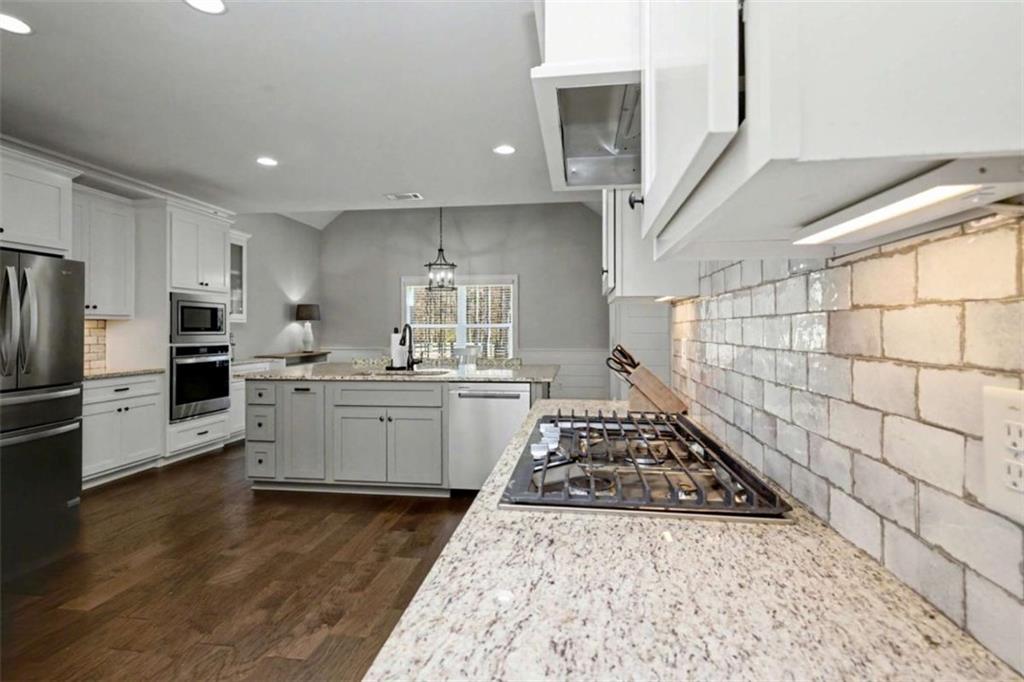 92 Gordon Oaks Way Moreland, GA 30259 - Photo 15 of 54 a large kitchen with a stove a sink dishwasher a refrigerator and white cabinets with wooden floor