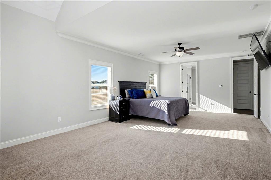 92 Gordon Oaks Way Moreland, GA 30259 - Photo 21 of 54 a spacious bedroom with a bed and a chandelier