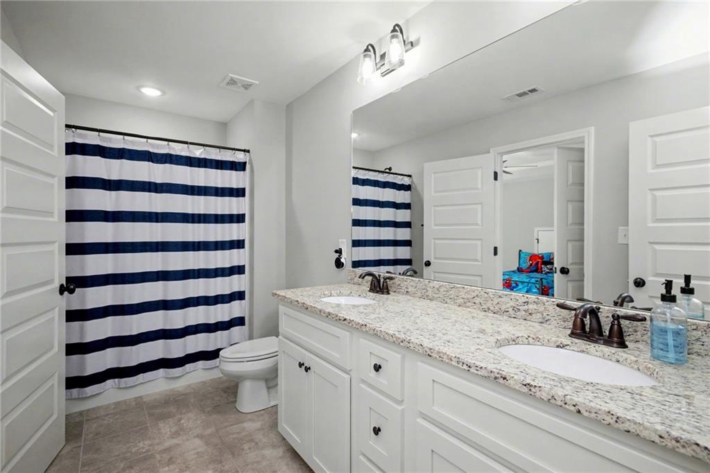 92 Gordon Oaks Way Moreland, GA 30259 - Photo 34 of 54 a bathroom with a granite countertop sink mirror vanity and toilet