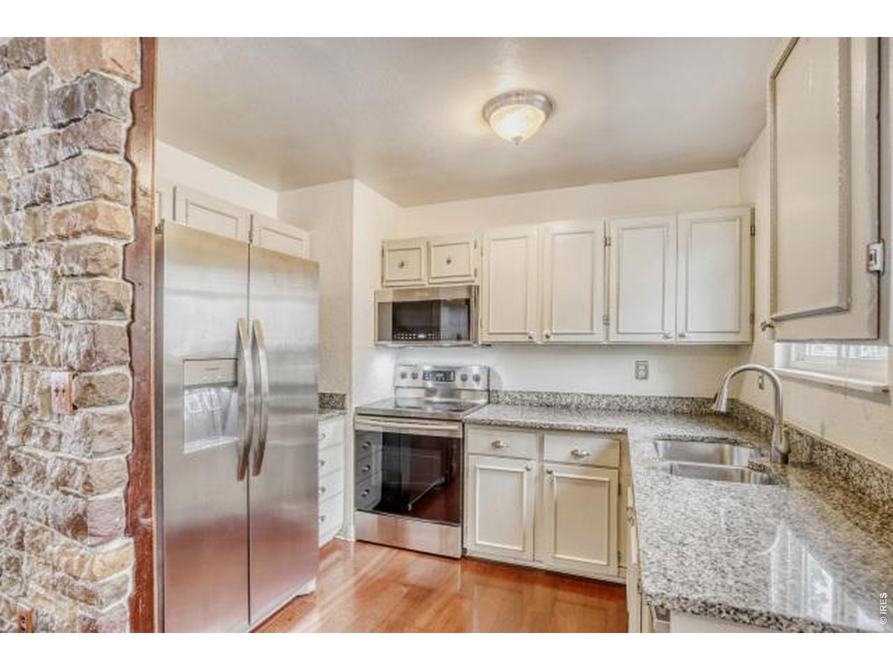10748 Routt Street Broomfield, CO 80021 - Photo 5 of 30 a kitchen with stainless steel appliances granite countertop a stove a sink and a refrigerator